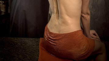 A person pouring water from a golden vessel into another person's hand.