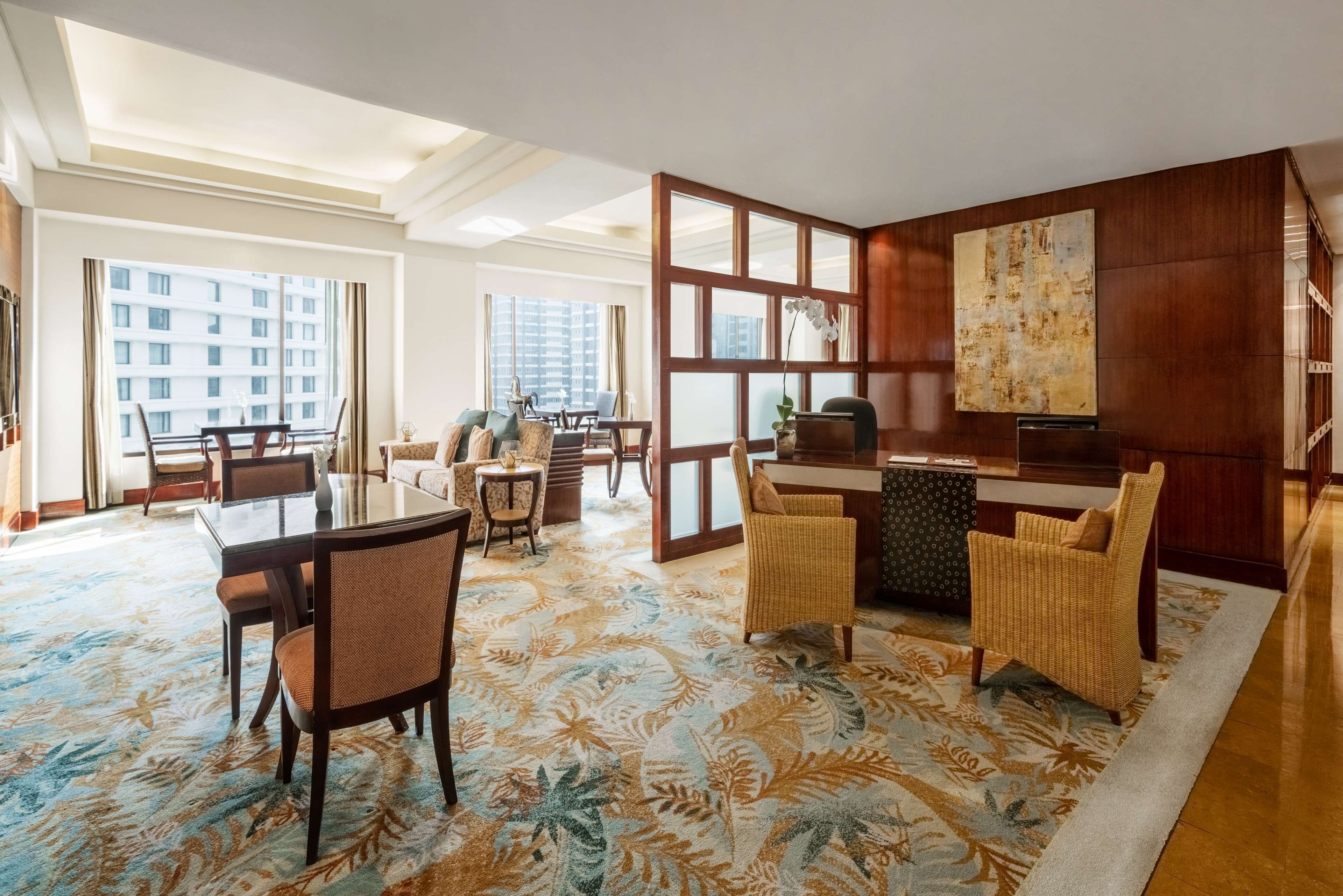 A spacious living area with a large window, a dining table, and comfortable seating.