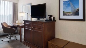 Une chambre d’hôtel équipée d’un bureau, d’une chaise, d’une télévision et d’un tableau encadré au mur.
