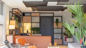 A modern interior with a sofa, chairs, a small table, and a potted plant. - ibis Nice Aéroport Promenade des Anglais (Nice)