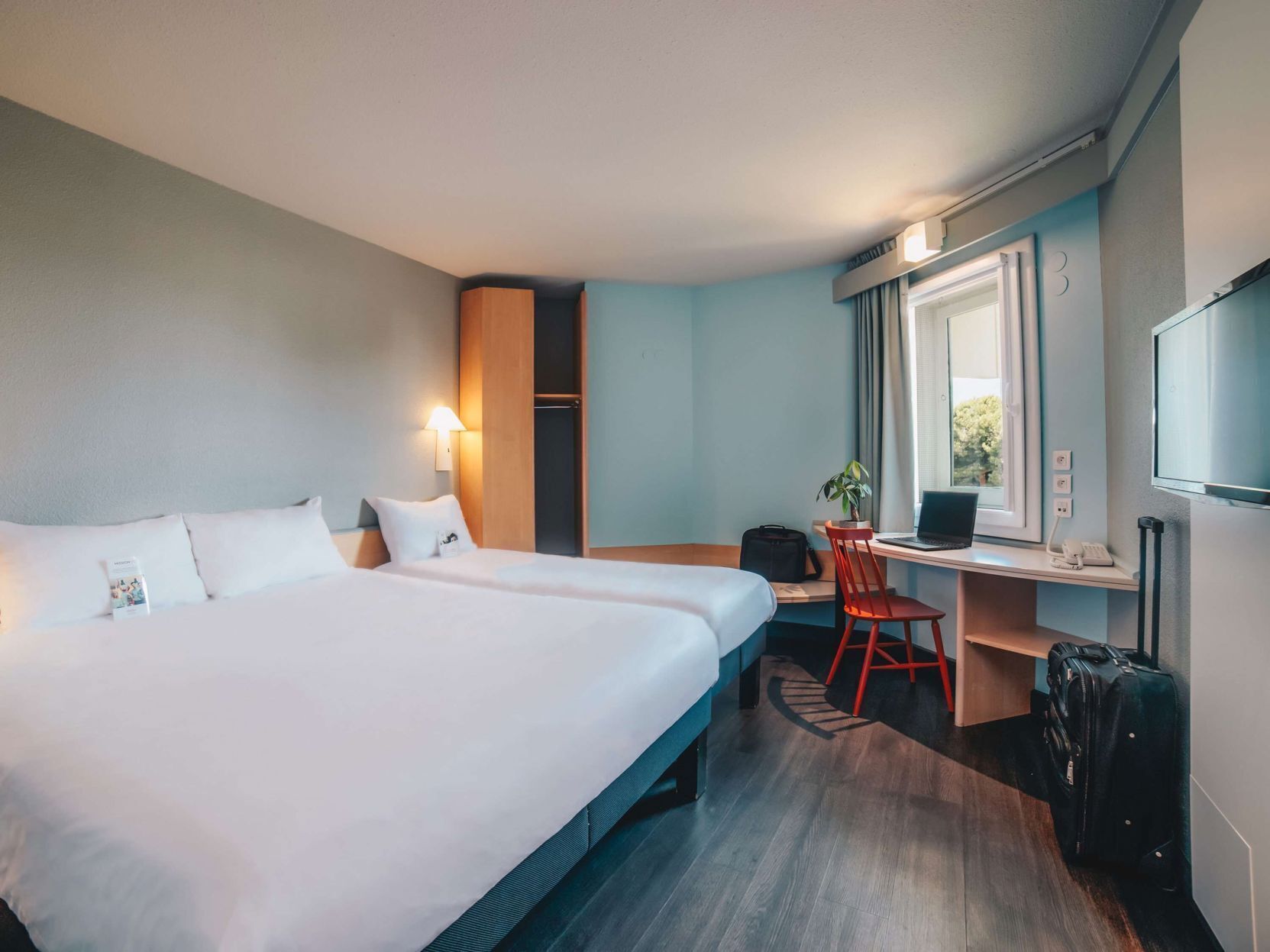 Hypo-allergenic bedding, desk, laptop workspace, blackout drapes