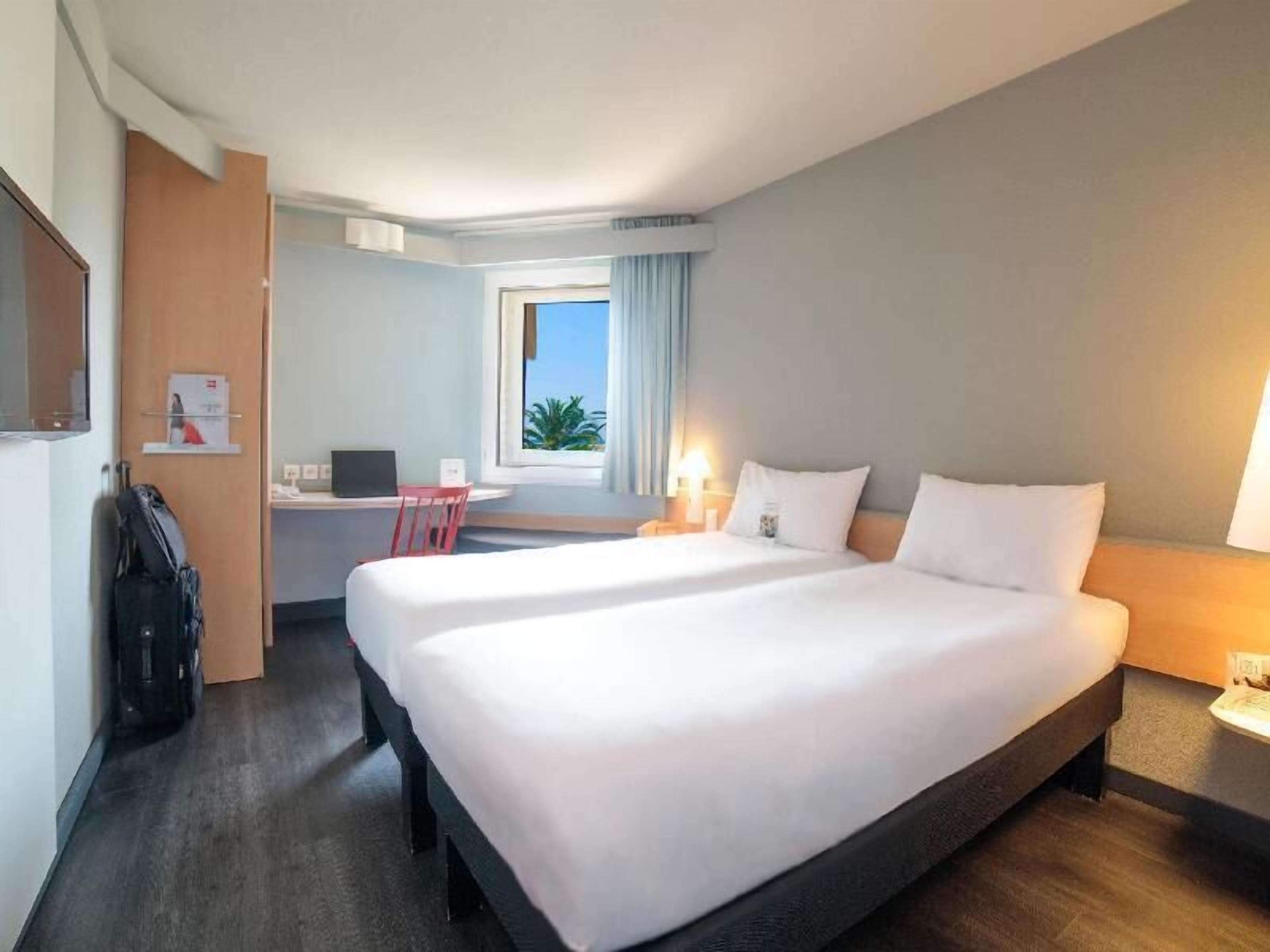 Hypo-allergenic bedding, desk, laptop workspace, blackout drapes