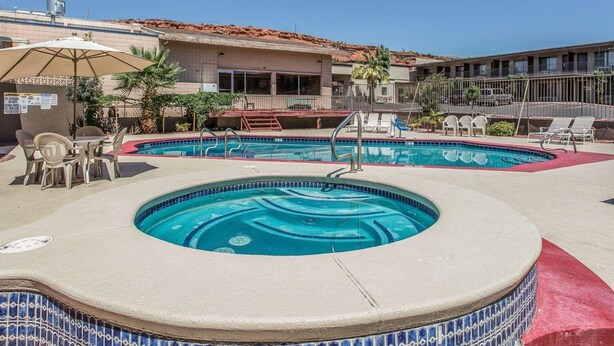 A hotel with a swimming pool, outdoor seating, and a view of the ocean.