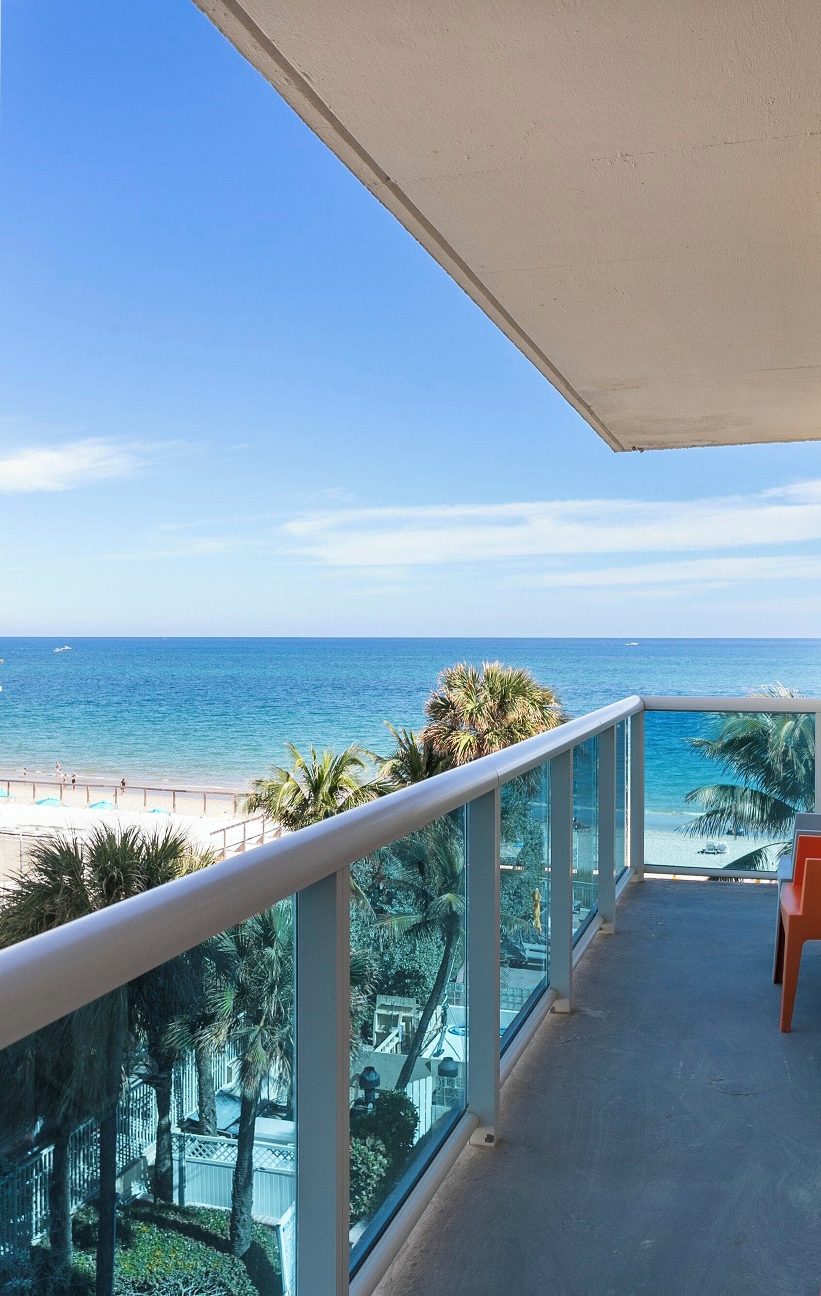 A balcony with a view of the beach and ocean.