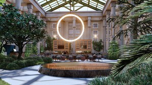 A spacious indoor atrium with a central circular fountain, surrounded by seating areas and a bar with a large illuminated sign. - Hyatt Regency Greenwich (Old Greenwich)