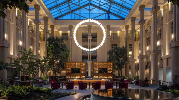 A spacious atrium with a central bar, surrounded by seating areas and a circular water feature. - Hyatt Regency Greenwich (Old Greenwich)