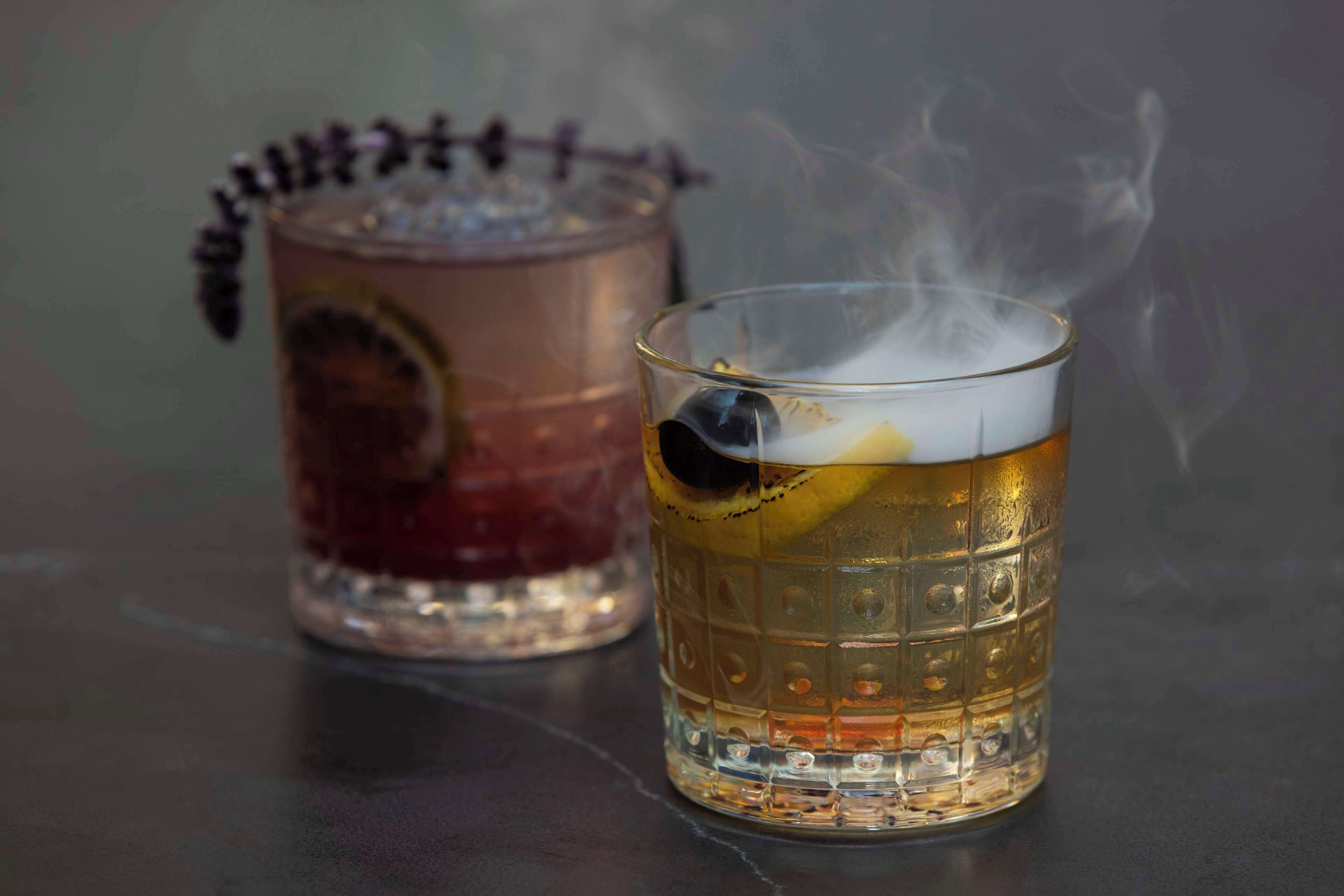 Two glasses of beer on a table with a blurred background.