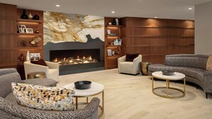 A modern living room with a fireplace, comfortable seating, and a decorative wall.