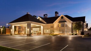 A hotel with a covered entrance, a parking lot, and a landscaped area with plants. - Homewood Suites by Hilton Harrisburg-West Hershey Area (Mechanicsburg)