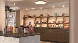 A self-service food station with various snacks and beverages, a refrigerated display, and a clean, modern design. - Homewood Suites by Hilton Harrisburg-West Hershey Area (Mechanicsburg)