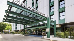 Un edificio moderno con entrada de vidrio y un letrero que dice "NH CONGRESS CENTER".