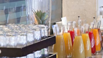 A bar area with multiple glasses of juice and a pineapple centerpiece.