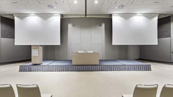 A conference room with a stage, a podium, and a seating area.