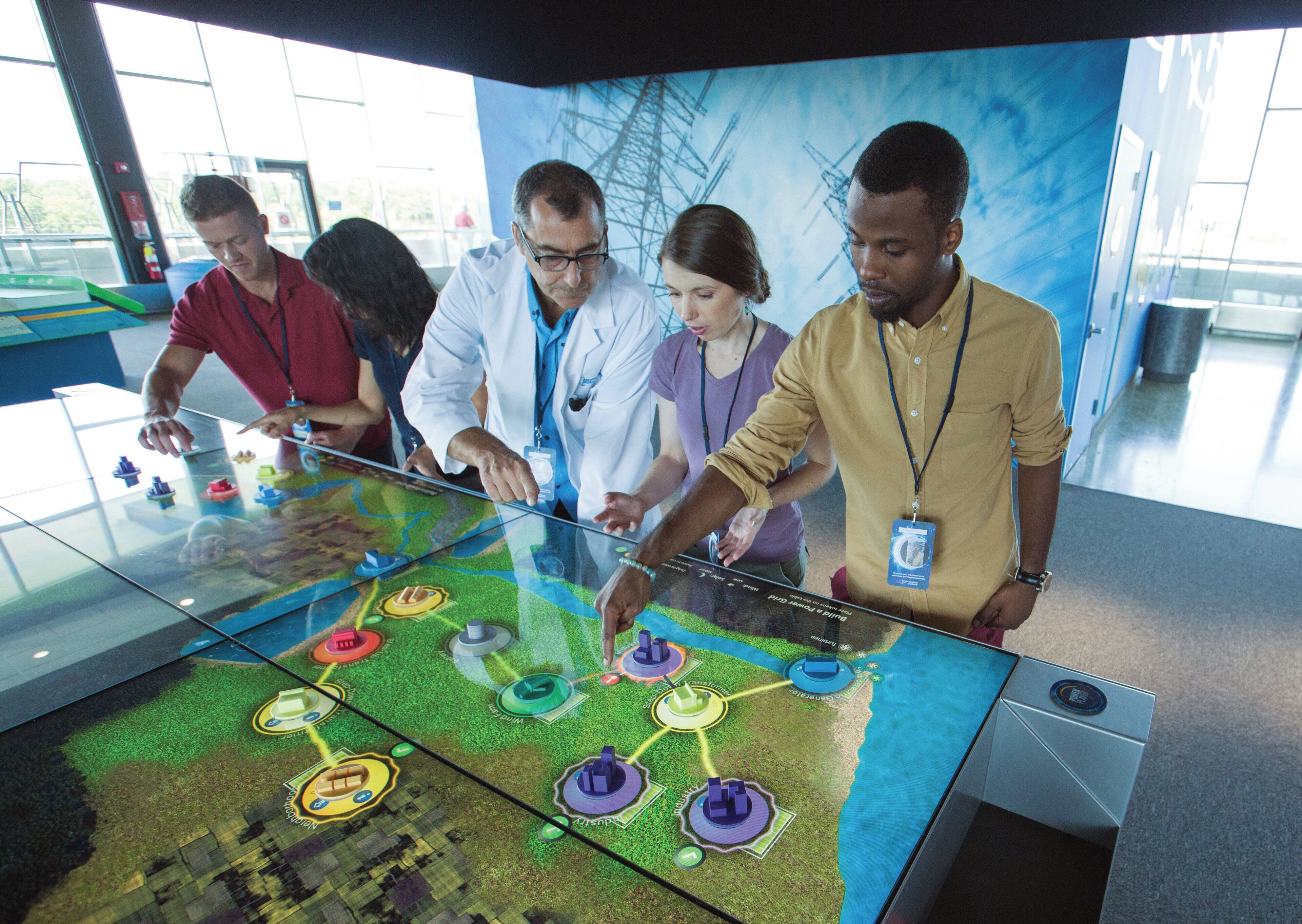 A group of people interacting with a digital interactive display.