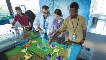 A group of people interacting with a digital interactive display.