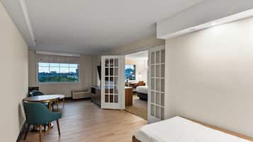 Een moderne hotelkamer met een bed, een bureau en een stoel. Er is uitzicht op de stad door het raam.