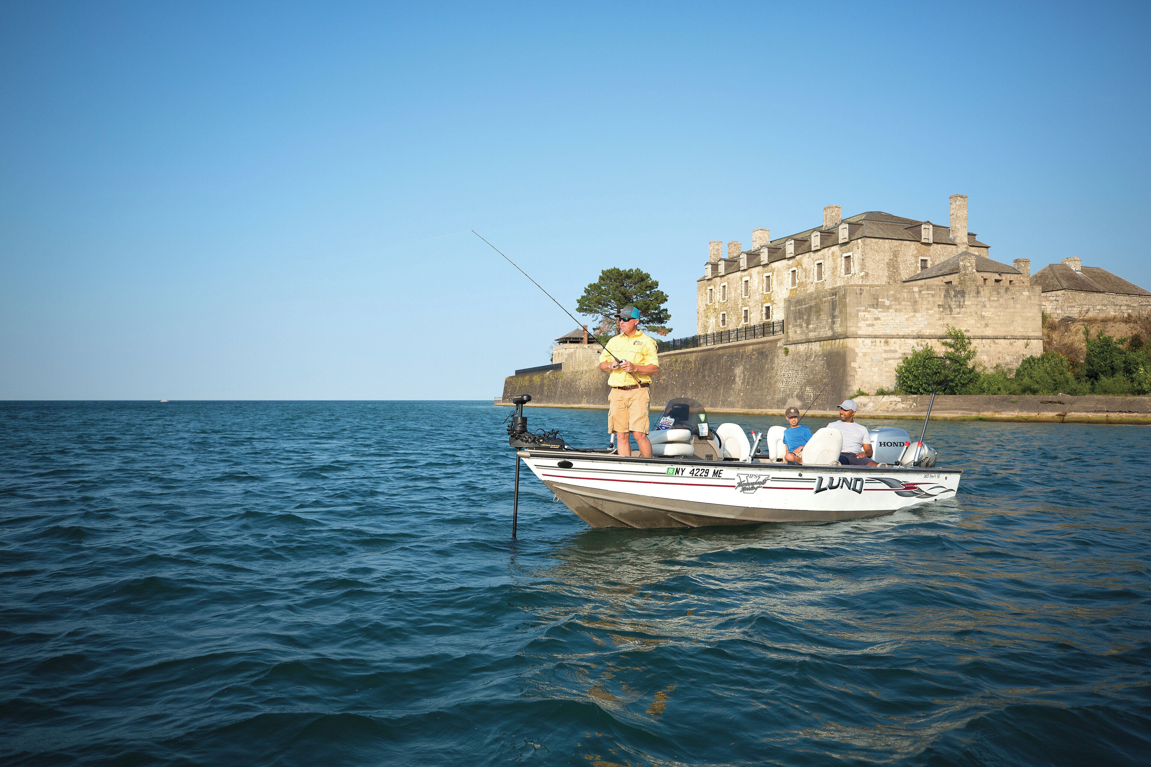 A boat named LUNO docked near a historic building by the water.