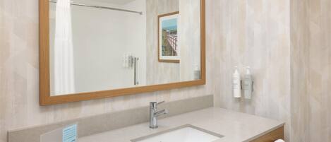 Un baño moderno con un espejo grande, un lavabo y un perchero para toallas.
