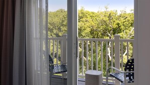 A wooden deck with white railings, two chairs, and a small round table.