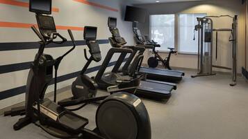 A gym with treadmills, elliptical machines, and a weight machine.
