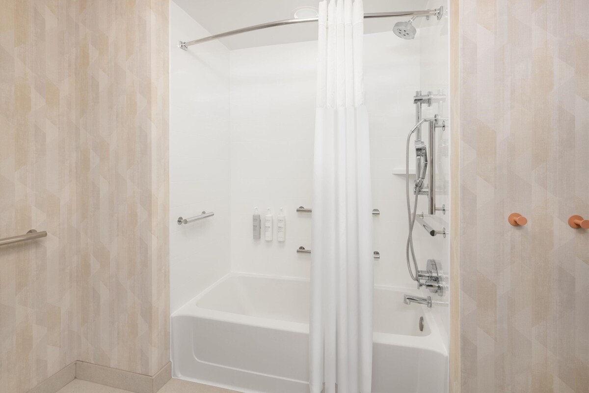 A modern bathroom with a walk-in shower, a bathtub, and a toilet.