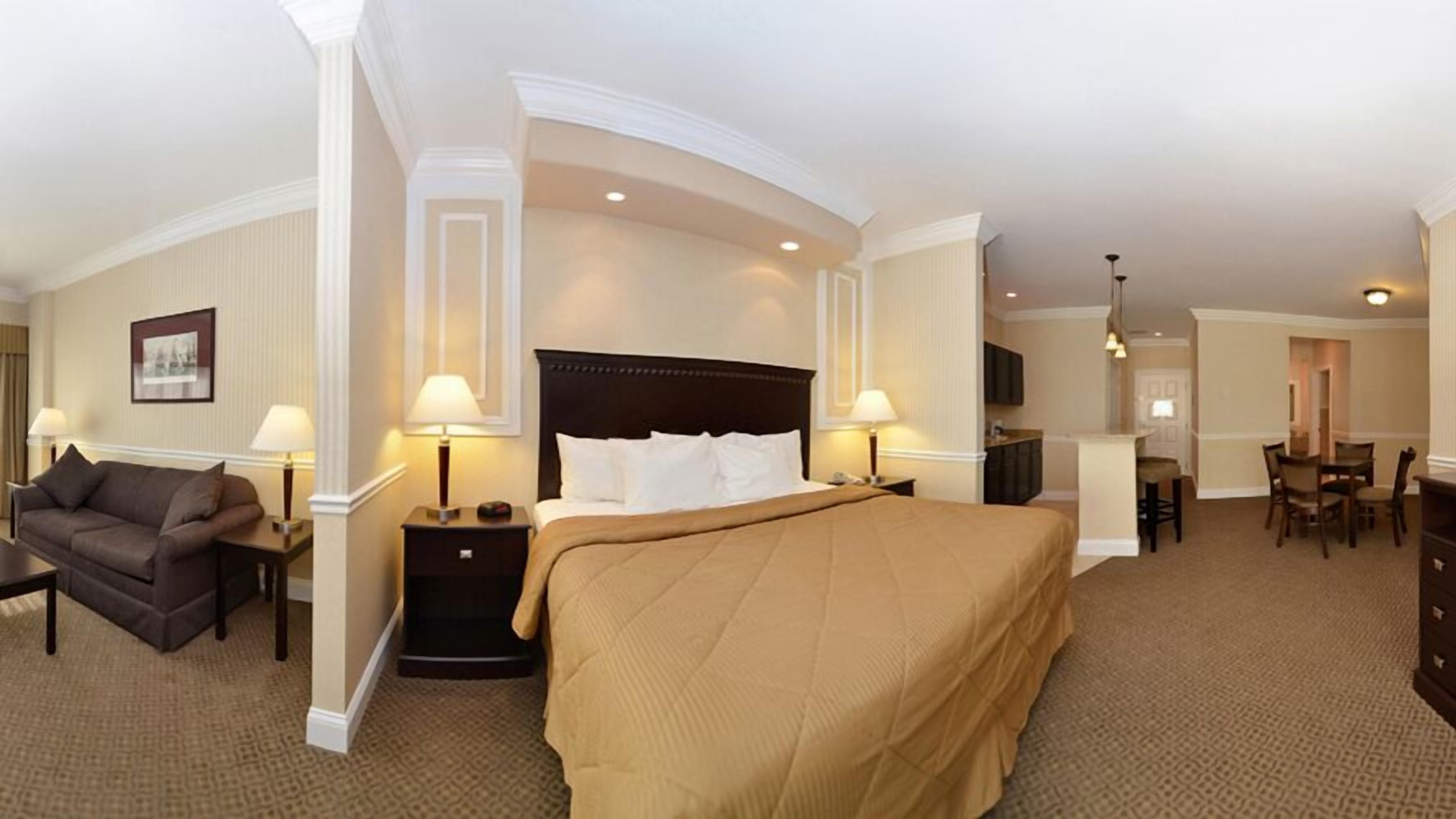 Une chambre d’hôtel avec un grand lit, un canapé, un bureau et un coin repas.