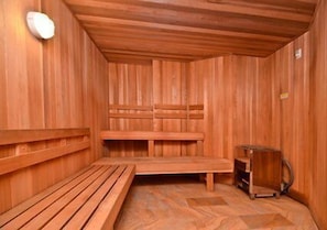 A wooden sauna with benches and a small table.