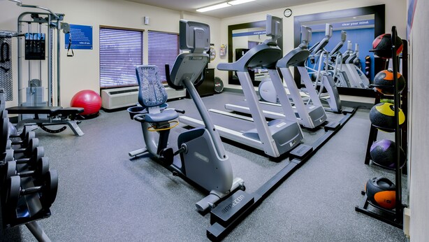 A gym with treadmills, elliptical machines, and free weights. - Pittsburgh Airport Inn and Suites (Coraopolis)