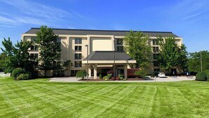 A multi-story building with a flat roof, surrounded by a well-maintained lawn and several trees. - Pittsburgh Airport Inn and Suites (Coraopolis)