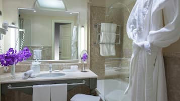 A bathroom with a sink, mirror, and a glass-enclosed shower.