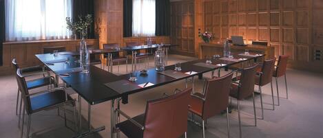 A conference room with a long table, chairs, and a laptop.