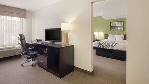 A hotel room with a desk, chair, television, lamp, and a bed with a canopy. - Sleep Inn Tanglewood (Roanoke)