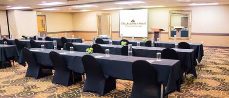 A conference room with tables set up for a meeting, equipped with water bottles and nameplates.