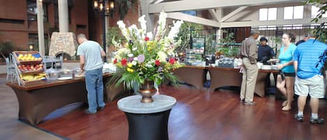 A buffet setup with a variety of fruits and a floral centerpiece.