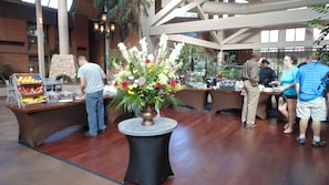 Una mesa de buffet con diversas frutas y un centro de mesa floral.