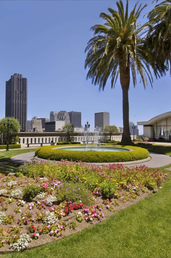 A landscaped garden with a palm tree, flower beds, and a fountain. - Fairmont San Francisco (San Francisco)