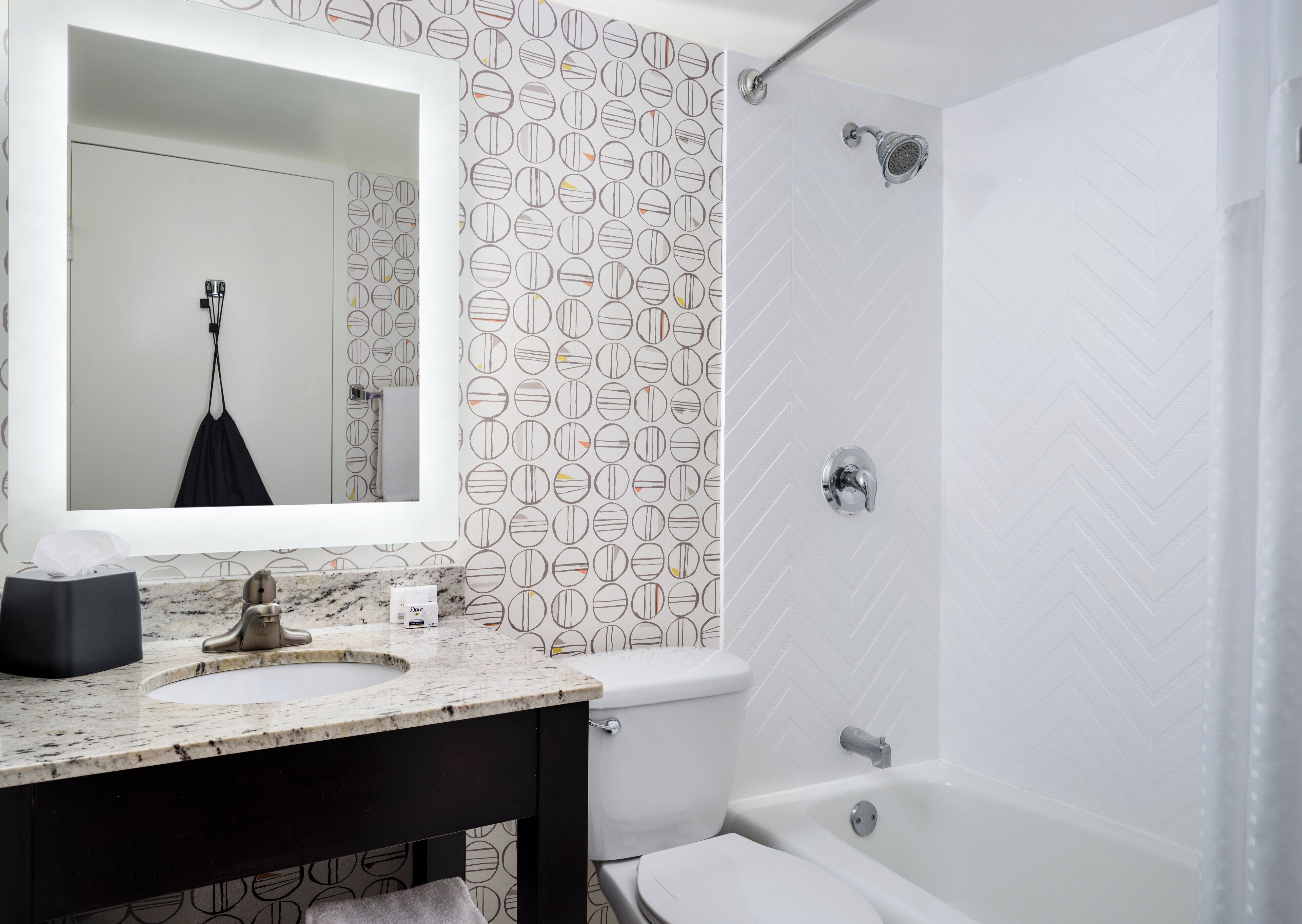 A bathroom with a sink, mirror, toilet, and shower.