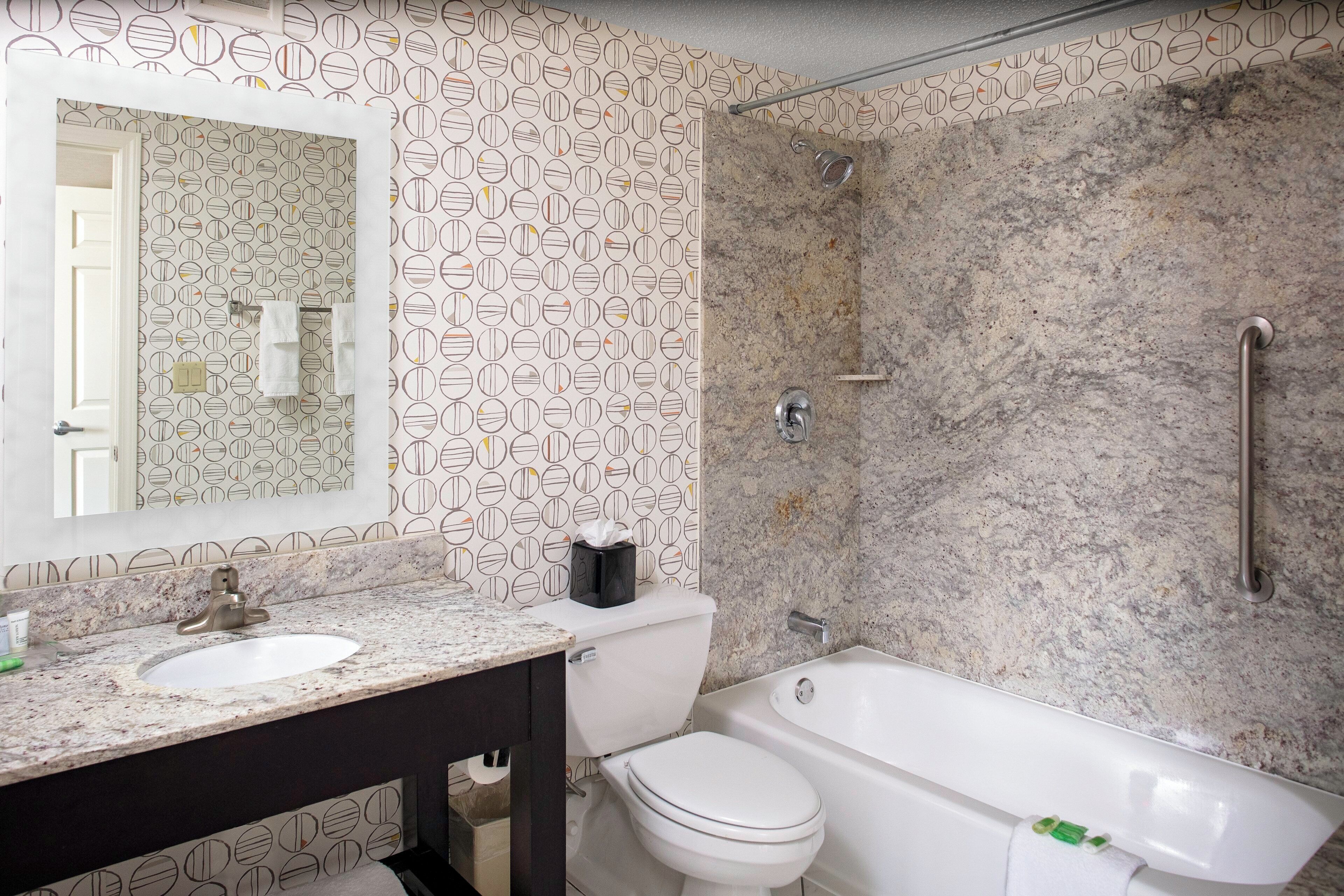 A bathroom with a marble sink, toilet, and bathtub.