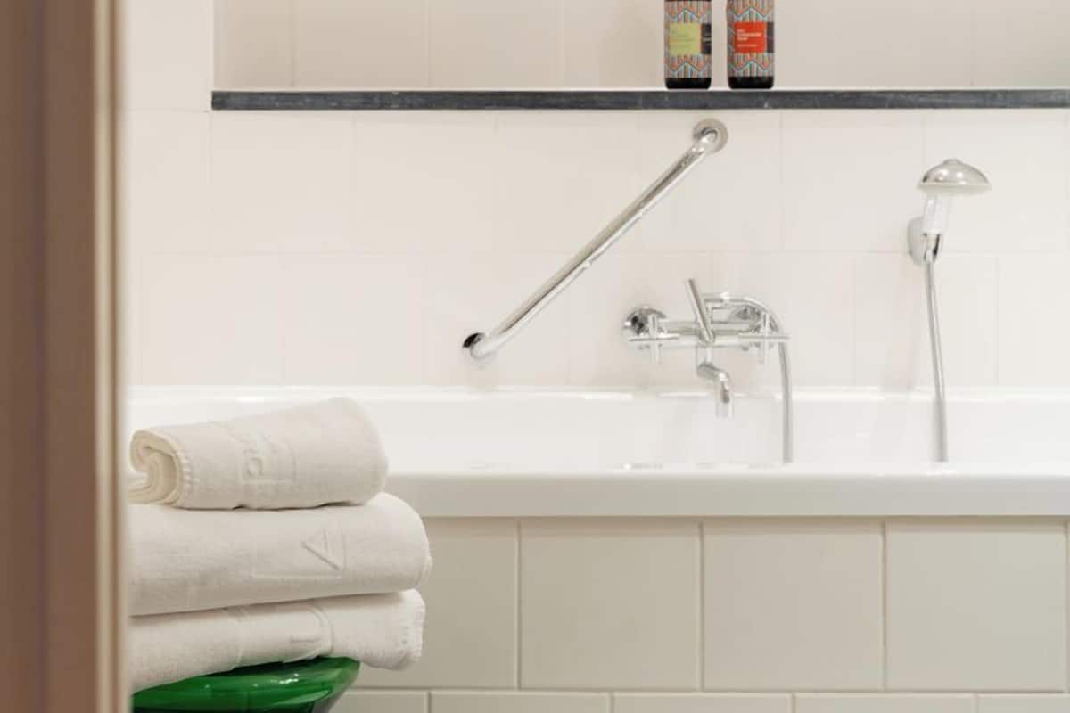 combined shower/bathtub, designer toiletries, hair dryer, towels