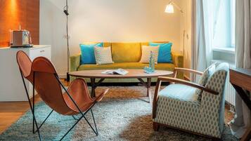 A modern living room with a sofa, two armchairs, a coffee table, and a small side table.