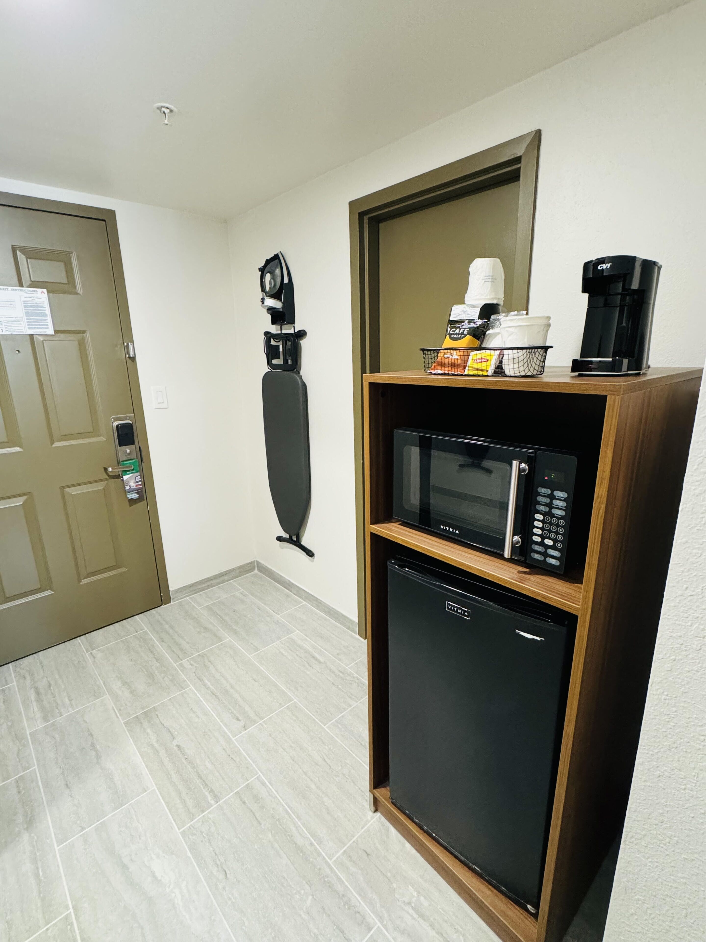 A compact kitchenette with a microwave, coffee maker, and a small refrigerator.