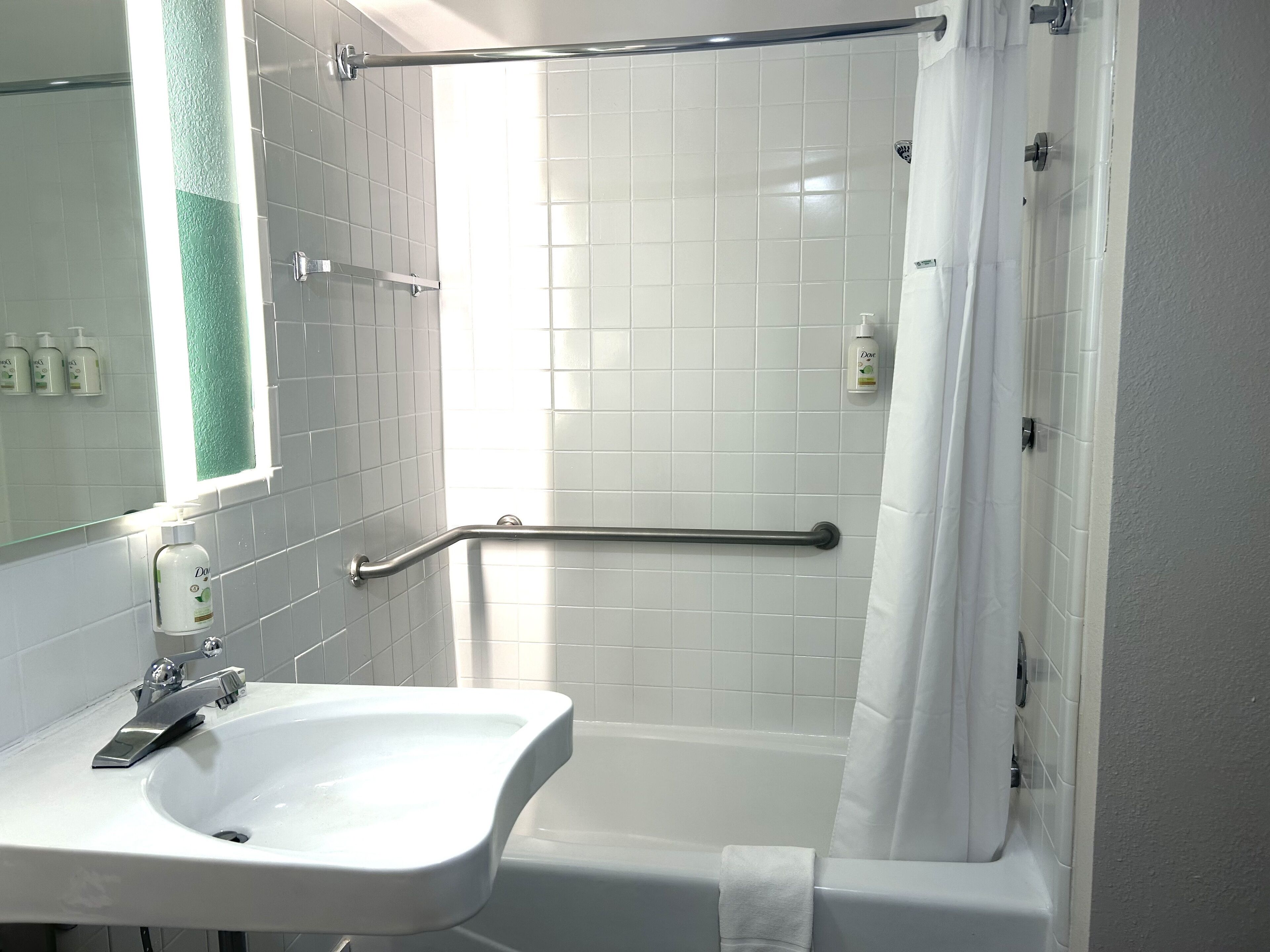 Une salle de bain avec un lavabo blanc, une douche en verre et une baignoire blanche.