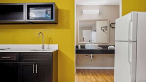 A kitchen with a microwave, sink, cabinets, and a refrigerator. - Signature Inn Danville (Danville)