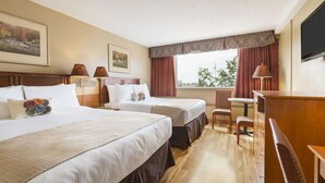 Een hotelkamer met twee bedden, een bureau, een stoel, een televisie en een raam met gordijnen.