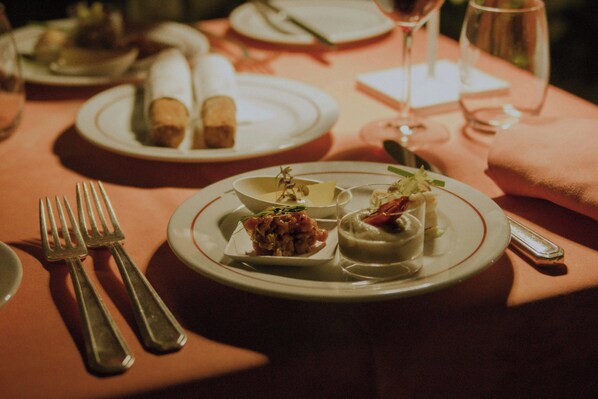 A table set with plates of food, cutlery, and wine glasses. - Sina Villa Medici, Autograph Collection (Florence)