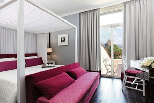 Una camera da letto con un letto, una poltrona, una scrivania e una sedia.