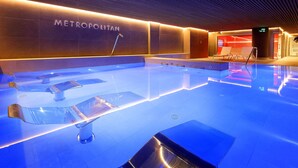 A modern indoor swimming pool with a 'METROPOLITAN' sign, clear water, and a sleek design. - Hesperia Sant Just (Sant Just Desvern)