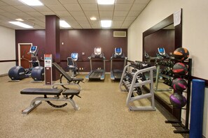 A gym with treadmills, elliptical machines, weight benches, and various exercise balls. - DoubleTree by Hilton Dallas - Richardson (Richardson)