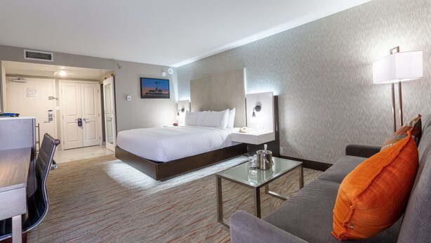 Une chambre d’hôtel comprenant un lit, un canapé, une table basse, un bureau et une chaise.