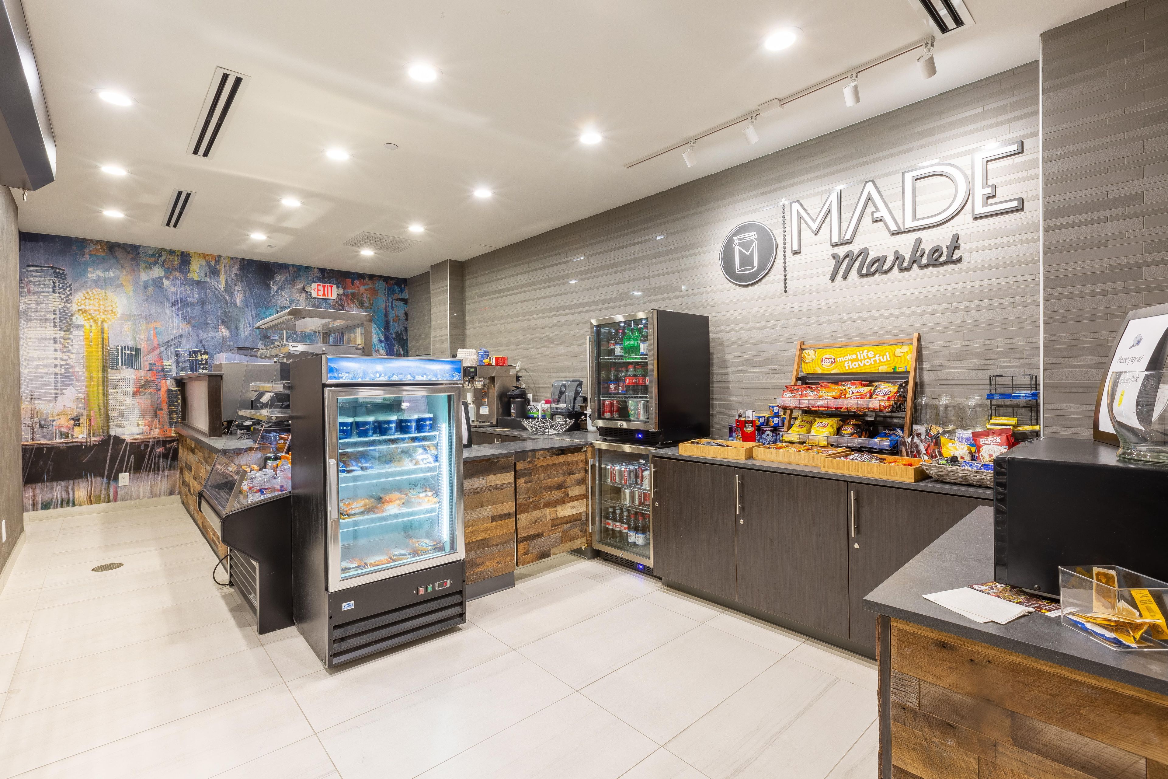 A modern retail space with a 'MADE Market' sign, refrigerated display cases, and a variety of products on shelves.